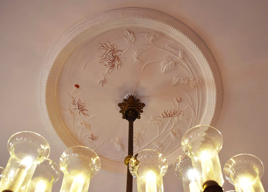 シャンデリアの接続部にある天井飾りの菊のこて絵
