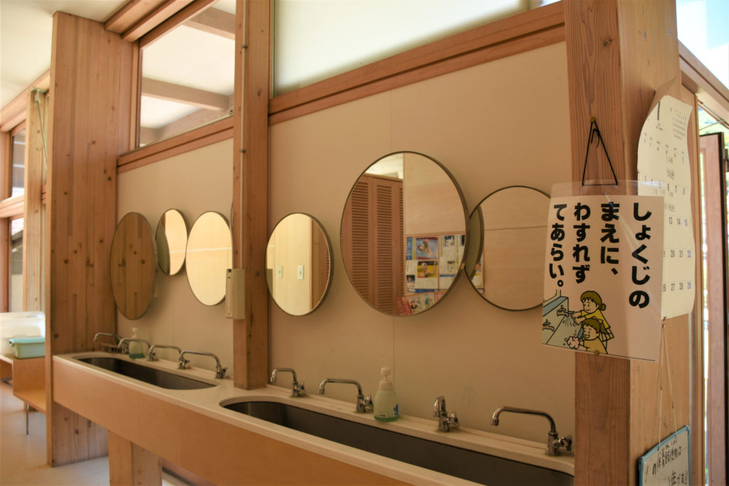 丸い鏡がおしゃれな学校のトイレ